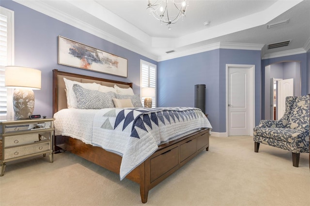 bedroom featuring ornamental molding, light carpet, a tray ceiling, and an inviting chandelier