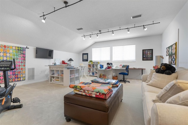 living room with vaulted ceiling, rail lighting, light colored carpet, and a textured ceiling