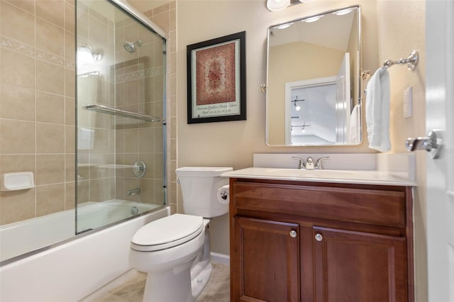 full bathroom with combined bath / shower with glass door, vanity, toilet, and tile patterned flooring