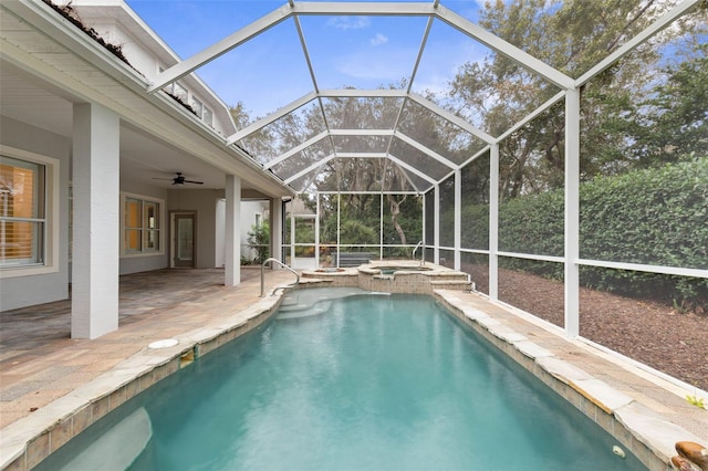 view of swimming pool with an in ground hot tub, glass enclosure, ceiling fan, and a patio area