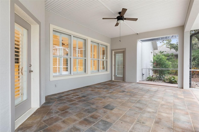 unfurnished sunroom featuring ceiling fan and wooden ceiling