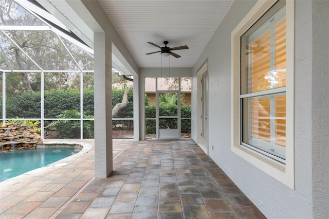 view of swimming pool featuring ceiling fan, a patio, and glass enclosure