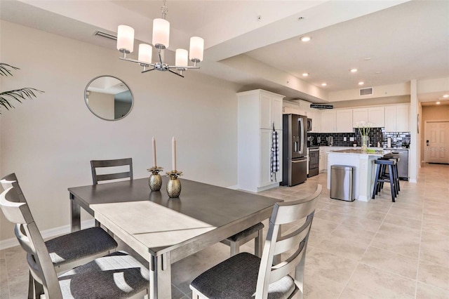 tiled dining room featuring an inviting chandelier