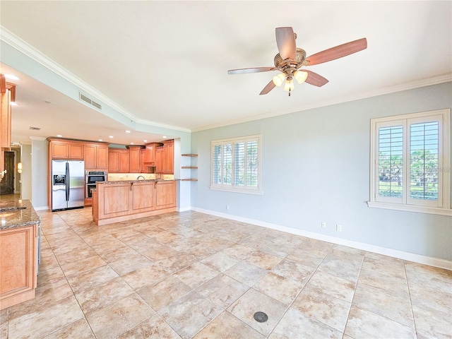 kitchen featuring stone counters, stainless steel fridge, ceiling fan, and ornamental molding