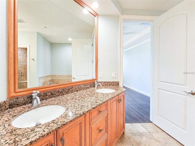 bathroom with tile patterned flooring, vanity, and walk in shower