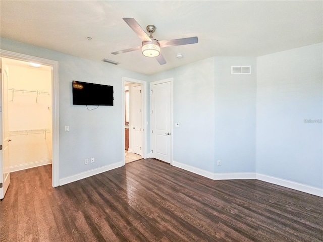 empty room featuring ceiling fan and dark wood-type flooring