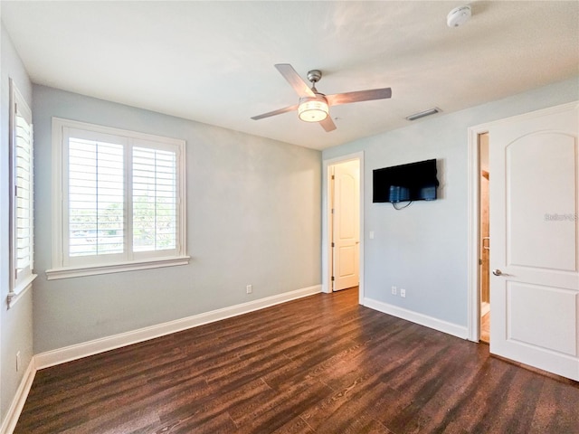 unfurnished bedroom with ceiling fan and dark wood-type flooring