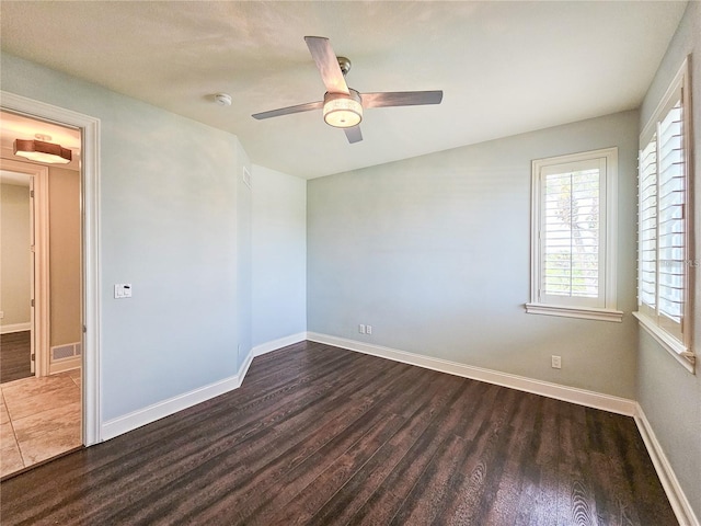 spare room with ceiling fan and dark wood-type flooring