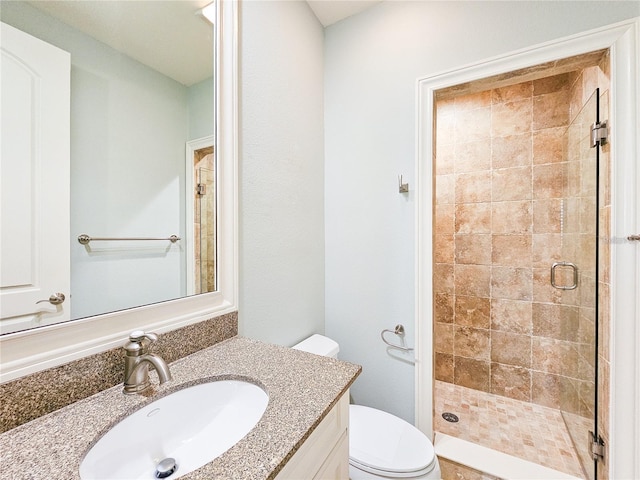 bathroom featuring walk in shower, vanity, and toilet