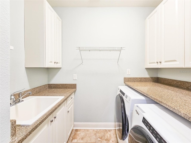 washroom with cabinets, light tile patterned floors, washing machine and dryer, and sink