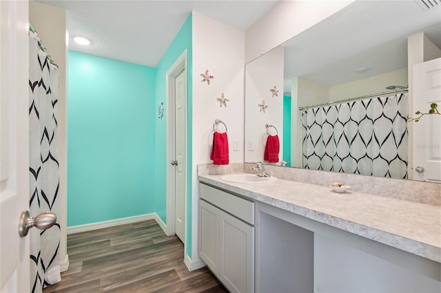 bathroom with hardwood / wood-style flooring, vanity, and a shower with shower curtain