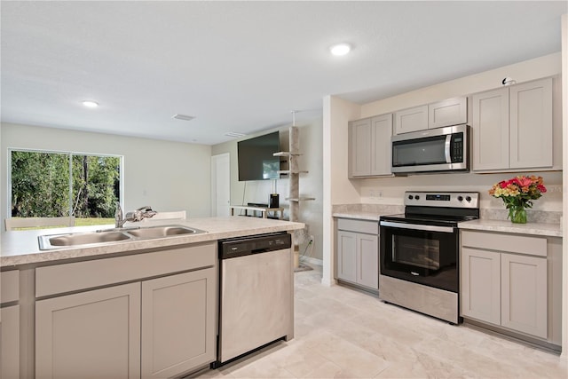 kitchen with stainless steel appliances, gray cabinets, and sink