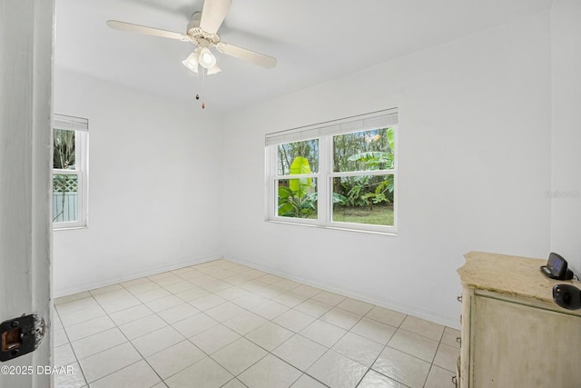 tiled empty room featuring ceiling fan