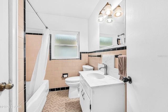 full bathroom with vanity, toilet, tile walls, and shower / tub combo