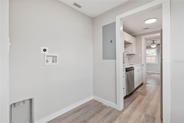 clothes washing area with hookup for an electric dryer, washer hookup, sink, light hardwood / wood-style flooring, and electric panel