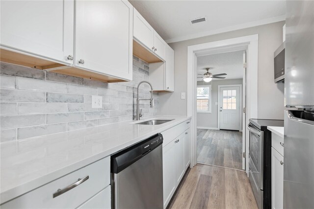 kitchen featuring white cabinets, appliances with stainless steel finishes, ceiling fan, and sink