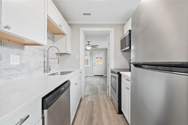 kitchen featuring white cabinetry, sink, light wood-type flooring, and appliances with stainless steel finishes