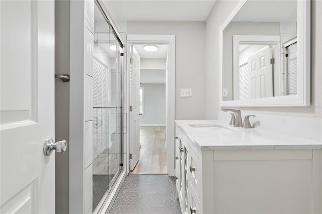 bathroom with tile patterned floors, vanity, and a shower with shower door