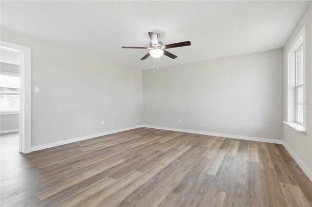 empty room with ceiling fan and light wood-type flooring