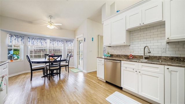 kitchen featuring stainless steel dishwasher, white cabinetry, and sink