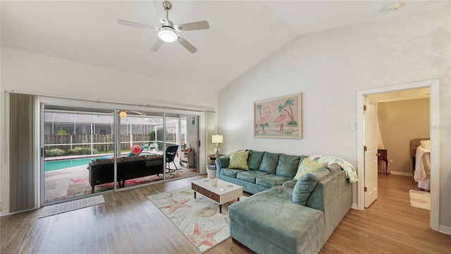 living room featuring ceiling fan, high vaulted ceiling, and light hardwood / wood-style flooring