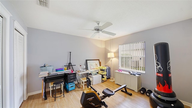 workout room featuring light wood-type flooring and ceiling fan