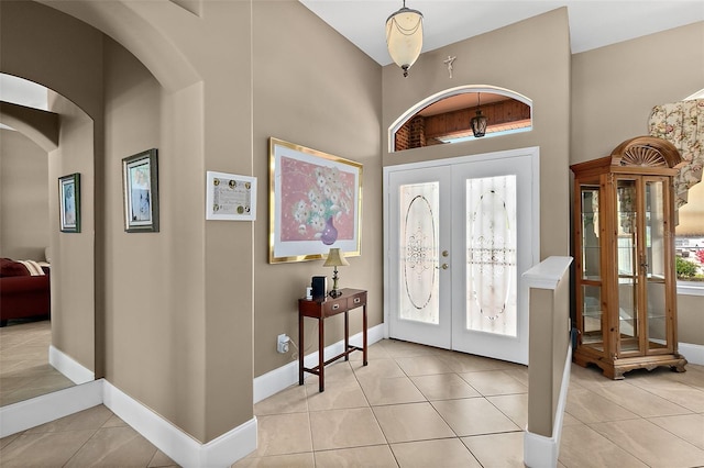 entryway with light tile patterned floors and french doors