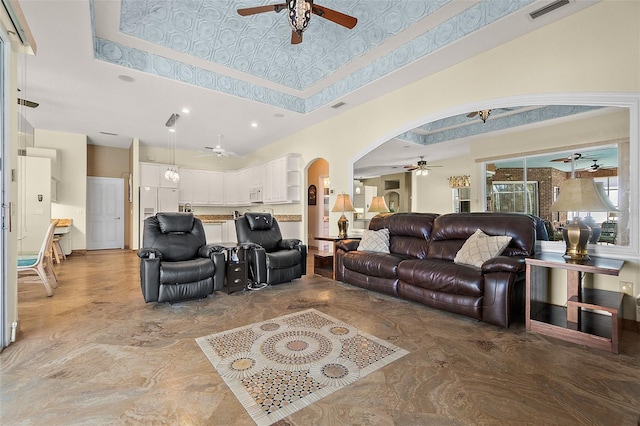 living room with a towering ceiling and a raised ceiling