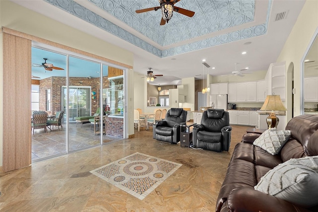 living room with a raised ceiling, brick wall, and a high ceiling