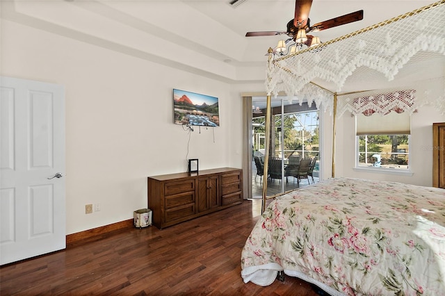 bedroom featuring a raised ceiling, access to exterior, ceiling fan, and dark wood-type flooring