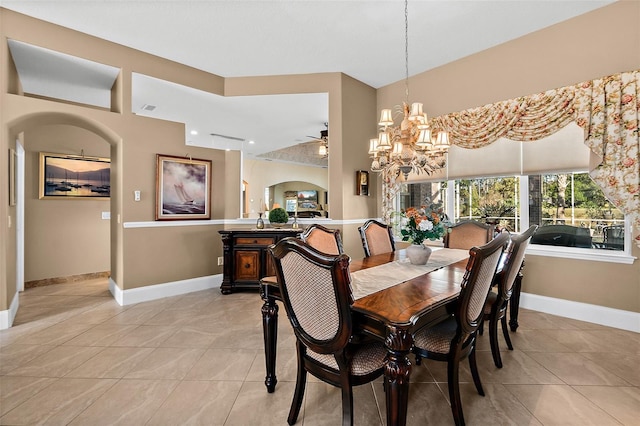 dining area with light tile patterned floors and ceiling fan with notable chandelier