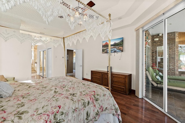 bedroom with access to outside and dark wood-type flooring