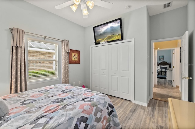 bedroom with ceiling fan, light hardwood / wood-style floors, and a closet