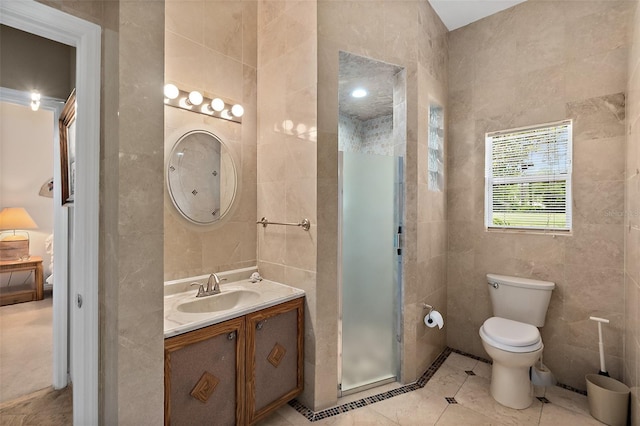 bathroom with tile patterned flooring, vanity, toilet, and tile walls