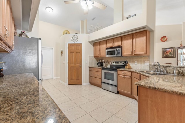 kitchen with high vaulted ceiling, stone countertops, light tile patterned floors, and appliances with stainless steel finishes