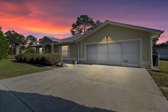 single story home featuring a lawn and a garage