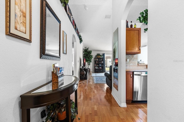 hall featuring a textured ceiling and light hardwood / wood-style flooring