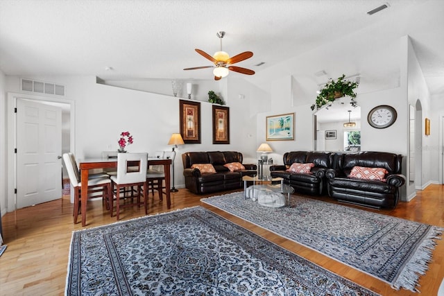 living room featuring hardwood / wood-style flooring, ceiling fan, a textured ceiling, and vaulted ceiling