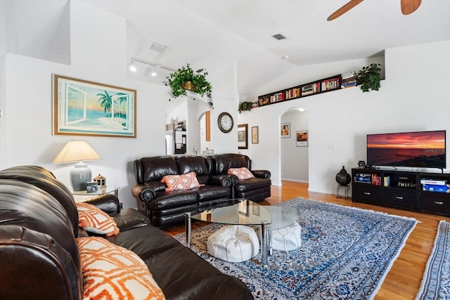 living room with hardwood / wood-style floors, a textured ceiling, ceiling fan, and lofted ceiling