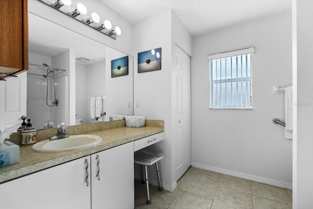 bathroom with tile patterned floors, a shower, vanity, and a textured ceiling