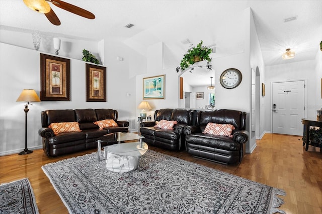 living room with wood-type flooring, a textured ceiling, vaulted ceiling, and ceiling fan