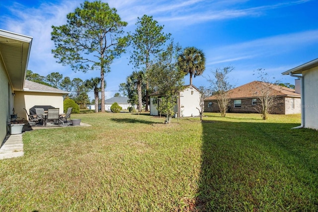 view of yard featuring a storage shed and a patio