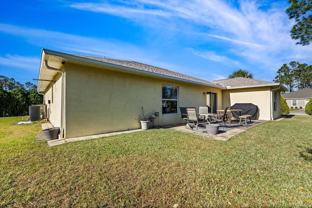 rear view of property with a patio, a lawn, and central air condition unit