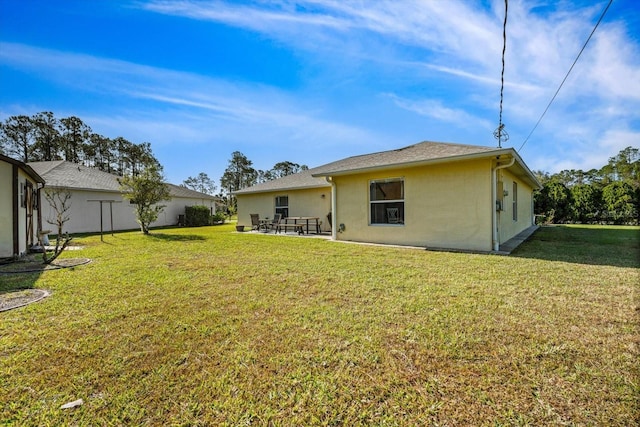 rear view of property featuring a lawn