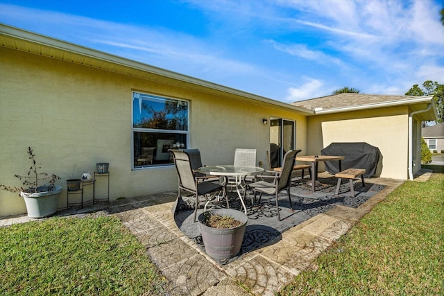 rear view of house with a lawn and a patio