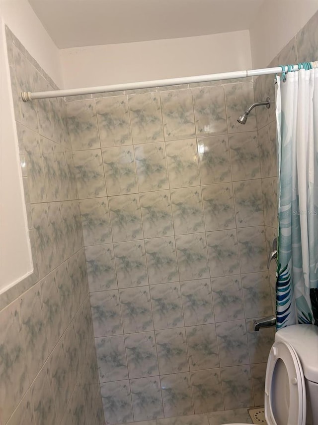 bathroom with curtained shower and toilet