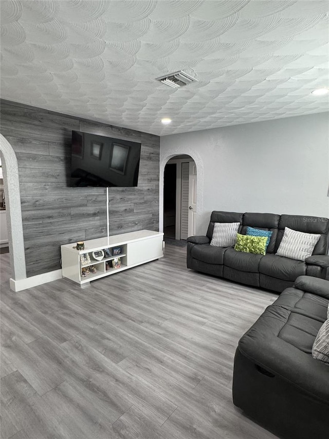 3565 NW 81st Ter, Miami, FL 33147 - living room with arched walkways, visible vents, light wood-style flooring, and baseboards