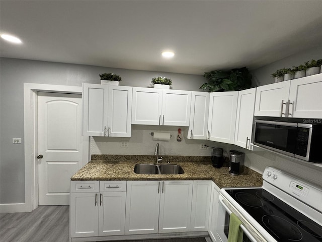 3565 NW 81st Ter, Miami, FL 33147 - kitchen with white range with electric stovetop, white cabinets, light wood-style flooring, stainless steel microwave, and a sink