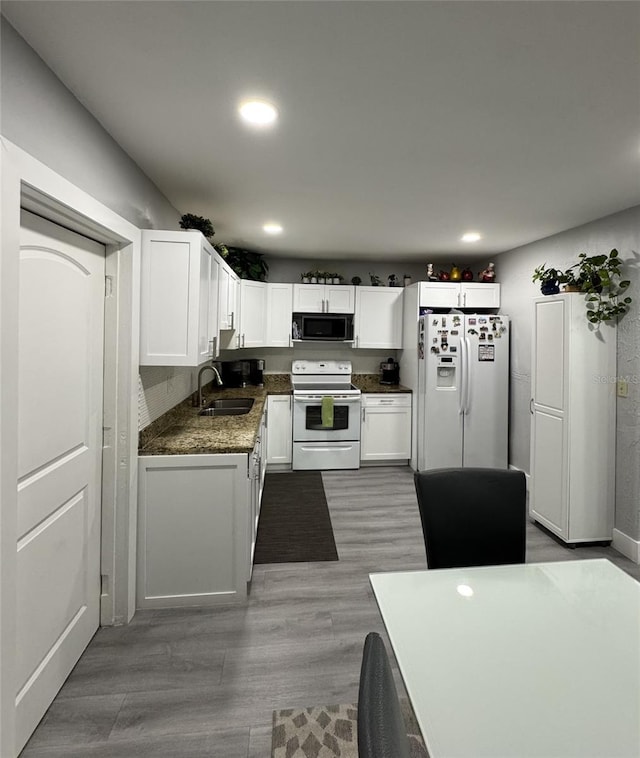 3565 NW 81st Ter, Miami, FL 33147 - kitchen with white appliances, white cabinets, a sink, and wood finished floors
