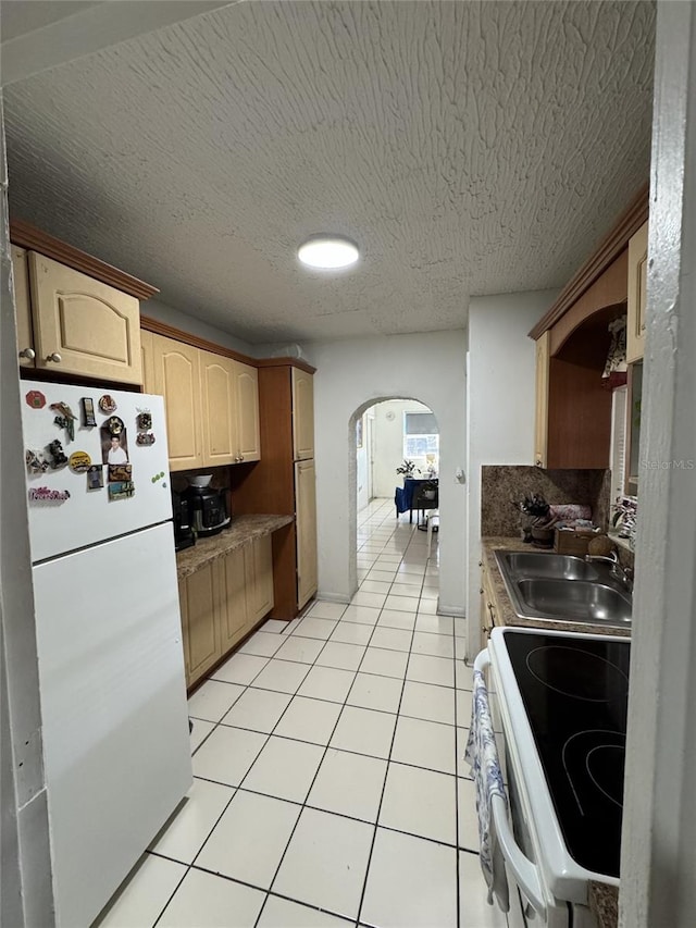3565 NW 81st Ter, Miami, FL 33147 - kitchen featuring white appliances, light tile patterned floors, arched walkways, light brown cabinets, and a sink